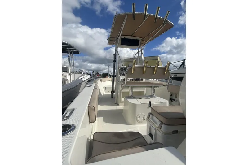 Slide: The Image of 2005 Hydra-Sports 212 CC boat interior with seating and rod holders under a blue sky. - 12