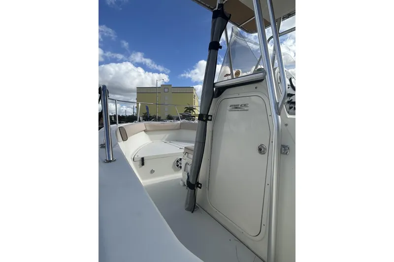 Slide: The Image of 2005 Hydra-Sports 212 CC boat interior with clear sky and building in background. - 13