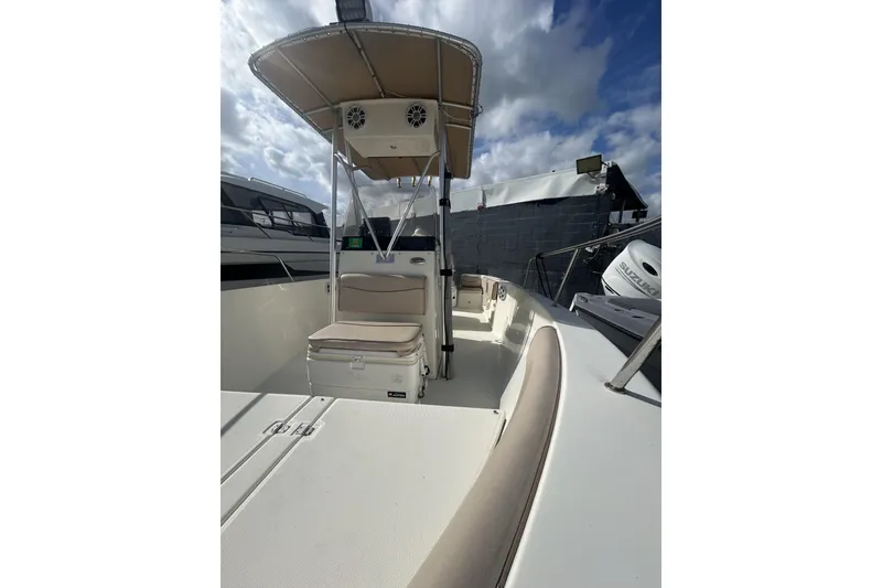 Slide: The Image of 2005 Hydra-Sports 212 CC boat with T-top, docked under cloudy sky. - 5