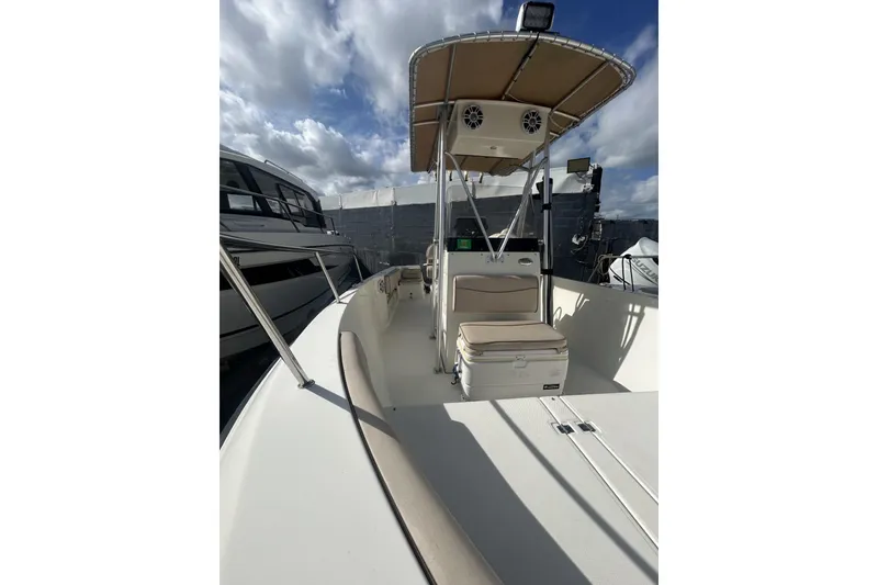 Slide: The Image of 2005 Hydra-Sports 212 CC boat with canopy, docked under a cloudy sky. - 6