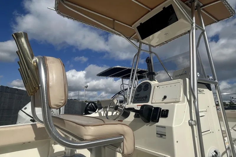 Slide: The Image of 2005 Hydra-Sports 212 CC boat interior with steering console and seating under a blue sky. - 9