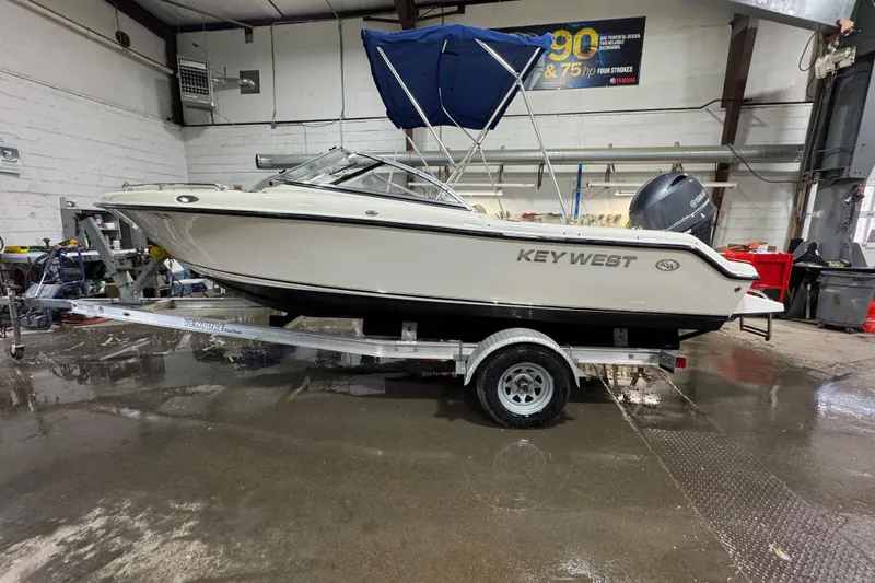 Slide: The Image of 2015 Key West 186 Dual Console boat on trailer in indoor garage setting. - 1