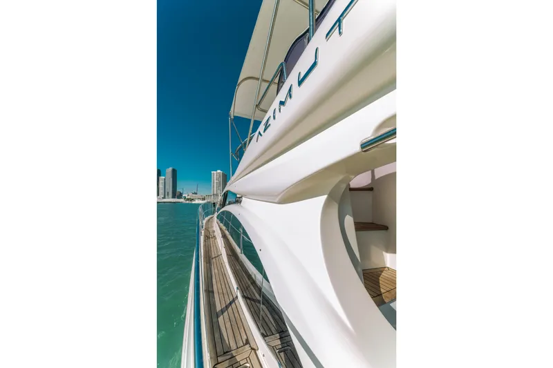 Slide: The Image of 2012 Azimut 48 Flybridge yacht with sleek design, docked near city skyline. - 7