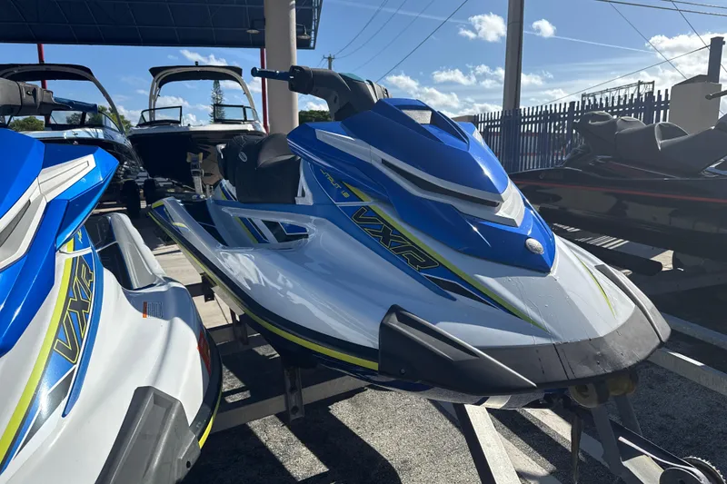 Slide: The Image of 2019 Yamaha WaveRunner VXR jet ski in blue and white, parked outdoors. - 12