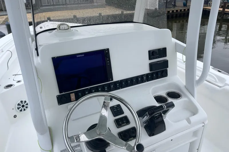 Slide: The Image of 2015 Sea Hunt Gamefish 27 boat console with steering wheel and navigation system. - 4