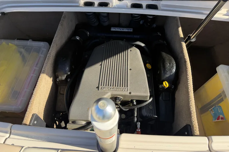Slide: The Image of Engine compartment of a 1999 MasterCraft MariStar 210 VRS boat, showing engine and storage. - 14