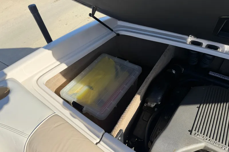 Slide: The Image of Open storage compartment in 1999 MasterCraft MariStar 210 VRS boat, containing a plastic container. - 16