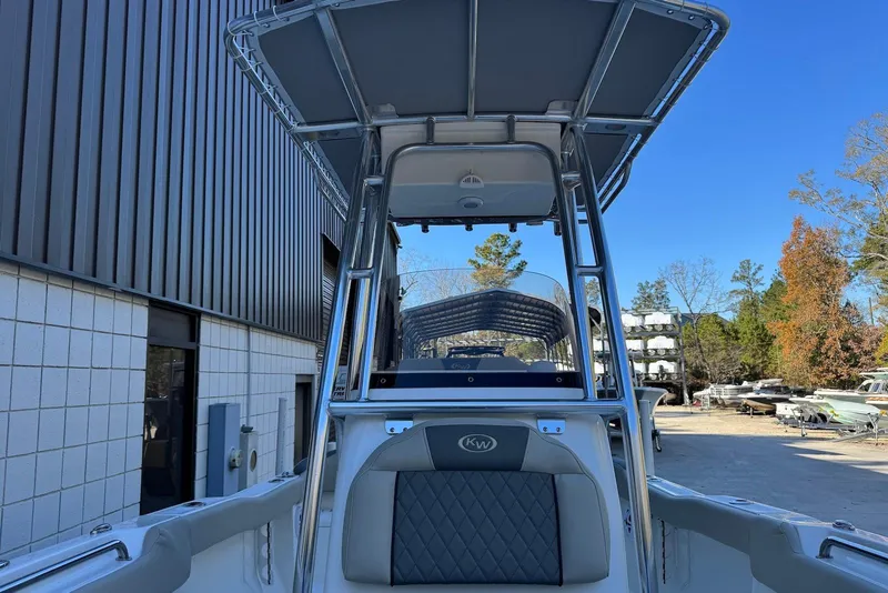 Slide: The Image of 2026 Key West 203 FS boat with T-top, parked outdoors under clear blue sky. - 14