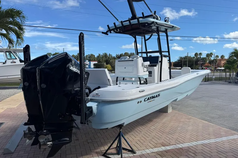 Slide: The Image of 2023 Caymas 28 HB Twin boat with dual Mercury engines, parked on a paved lot. - 12
