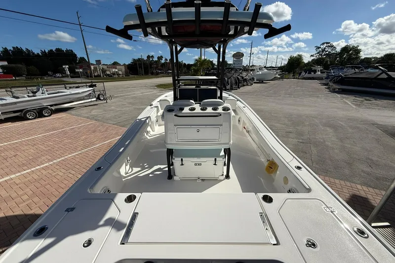 Slide: The Image of 2023 Caymas 28 HB Twin boat interior with console and seating, parked outdoors. - 15