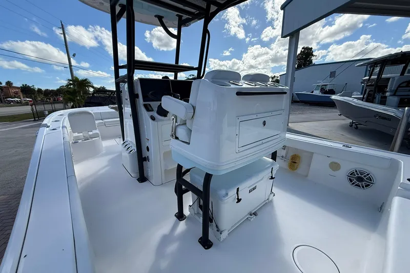 Slide: The Image of 2023 Caymas 28 HB Twin boat interior with helm and seating under a blue sky. - 23