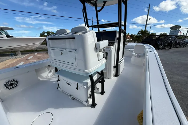 Slide: The Image of 2023 Caymas 28 HB Twin boat interior with seating and console, parked outdoors. - 24