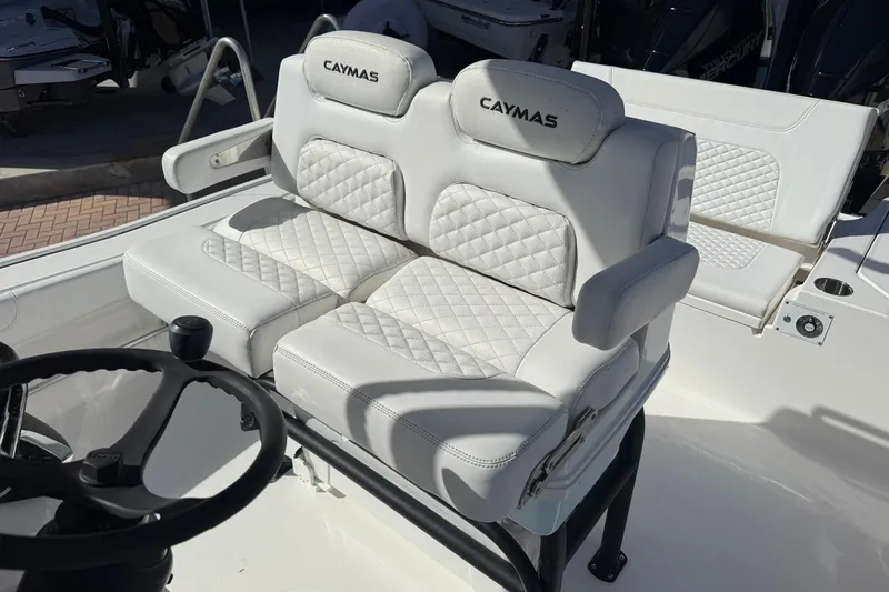 Slide: The Image of 2023 Caymas 28 HB Twin boat with luxurious white seating and steering wheel. - 28