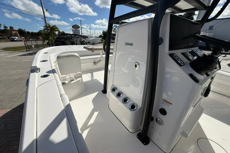 Slide: The Image of 2023 Caymas 28 HB Twin boat console with seating, under a sunny sky. - 30