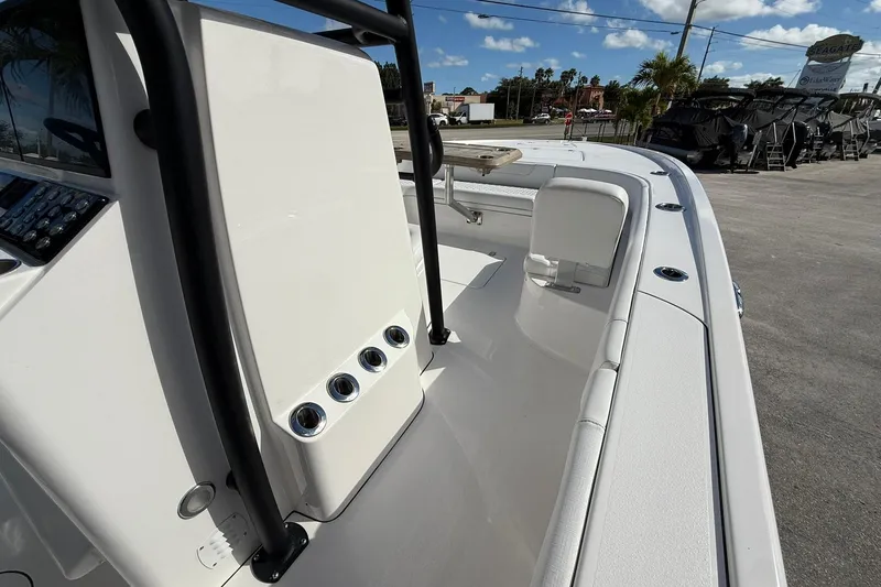 Slide: The Image of 2023 Caymas 28 HB Twin boat interior with seating and console, under a clear blue sky. - 31