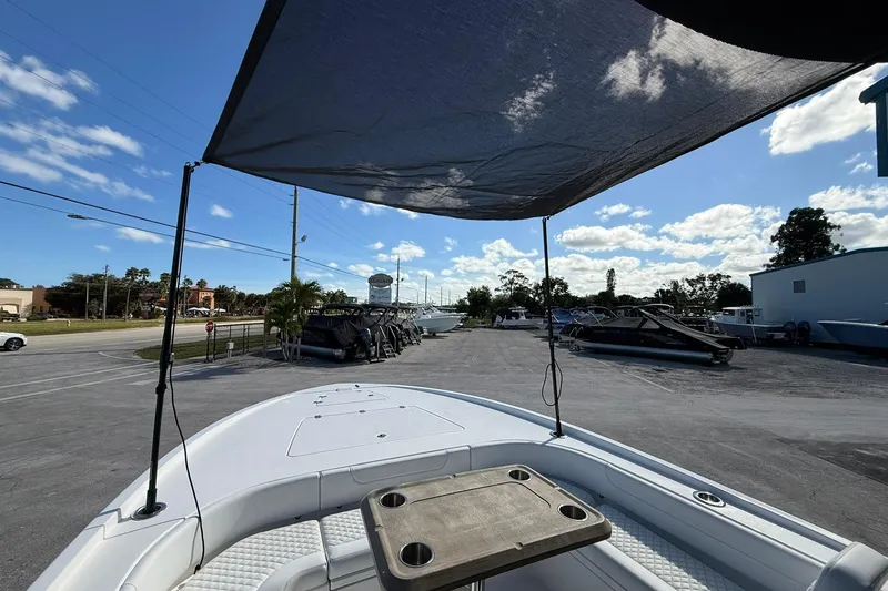 Slide: The Image of 2023 Caymas 28 HB Twin boat with canopy, parked in a sunny lot. - 32