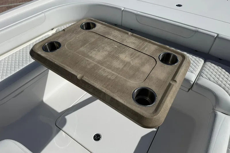 Slide: The Image of 2023 Caymas 28 HB Twin boat interior with wooden table and cup holders. - 34