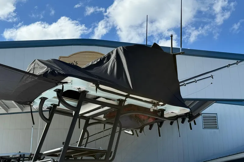 Slide: The Image of 2023 Caymas 28 HB Twin boat with covered top, docked under blue sky. - 6