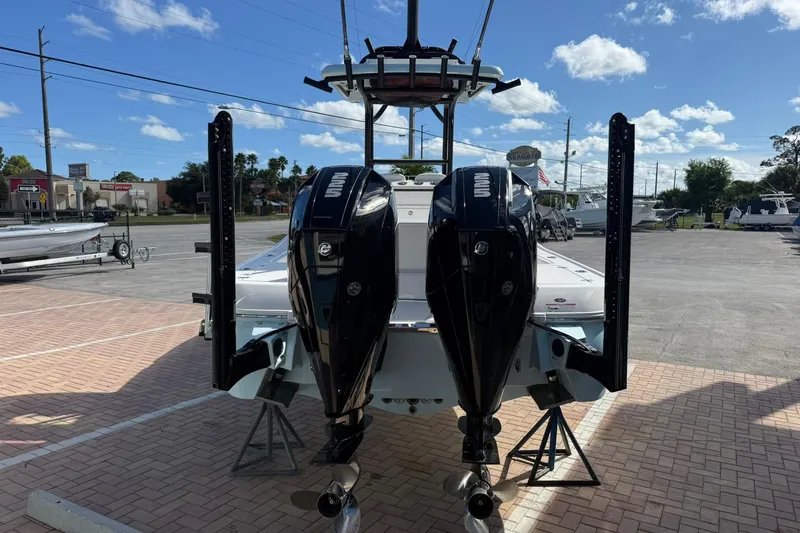 Slide: The Image of 2023 Caymas 28 HB Twin boat with dual outboard engines in a parking lot. - 9