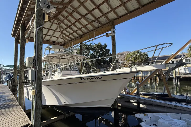 The Image of 2005 Grady-White Bimini 306 boat docked under a wooden shelter. - 0