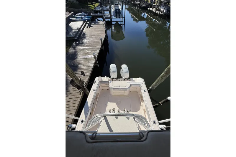 Slide: The Image of 2005 Grady-White Bimini 306 boat docked in a serene marina setting. - 10