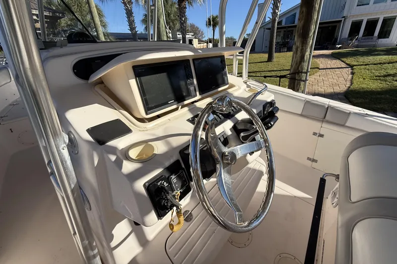 Slide: The Image of 2005 Grady-White Bimini 306 boat helm with dual screens and steering wheel. - 14