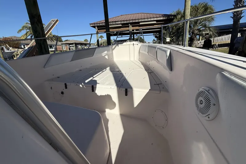 Slide: The Image of 2005 Grady-White Bimini 306 boat interior with seating and speaker, docked outdoors. - 18