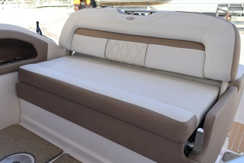 Slide: The Image of 2018 Regal 28 Express boat interior seating with beige and white upholstery. - 12