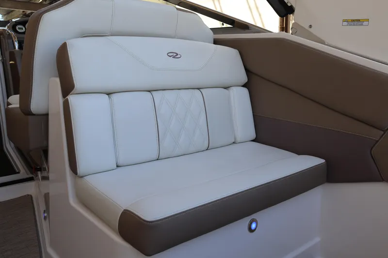 Slide: The Image of 2018 Regal 28 Express boat interior with white and brown cushioned seating. - 13
