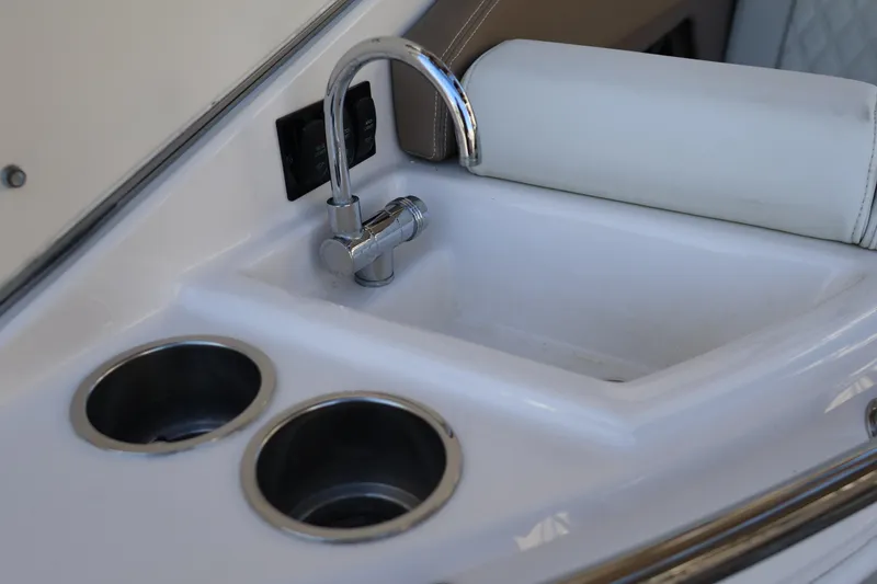 Slide: The Image of Compact sink and cup holders on 2018 Regal 28 Express boat interior. - 19