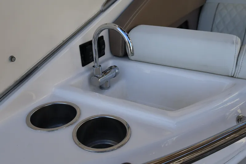 Slide: The Image of 2018 Regal 28 Express boat sink with faucet and cup holders. - 20