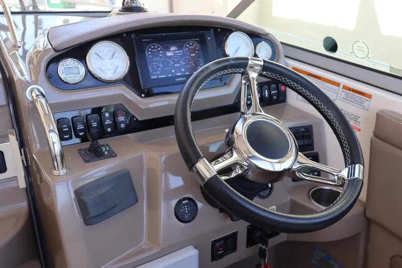 Slide: The Image of 2018 Regal 28 Express boat dashboard with steering wheel and navigation controls. - 21