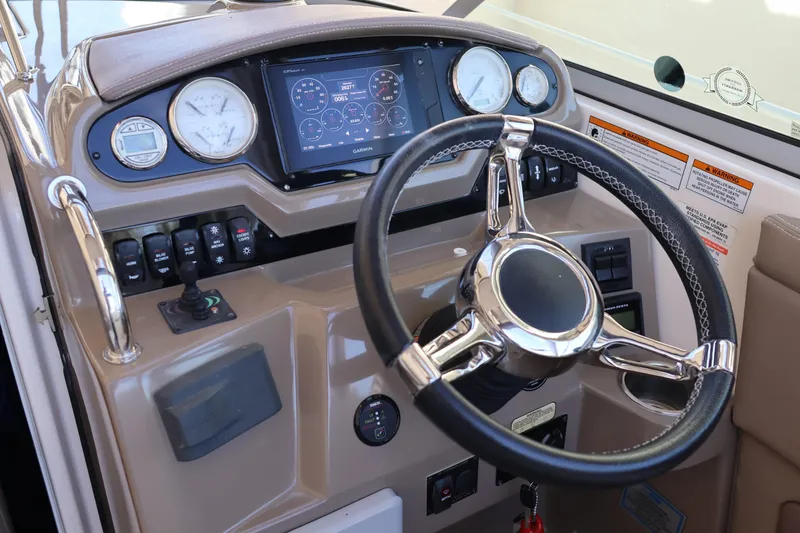 Slide: The Image of 2018 Regal 28 Express boat dashboard with steering wheel and navigation controls. - 23