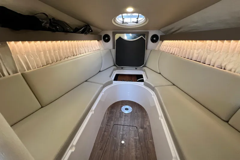 Slide: The Image of 2018 Regal 28 Express boat interior with beige seating and wood flooring. - 28