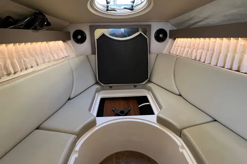 Slide: The Image of 2018 Regal 28 Express boat interior with beige seating and ambient lighting. - 29