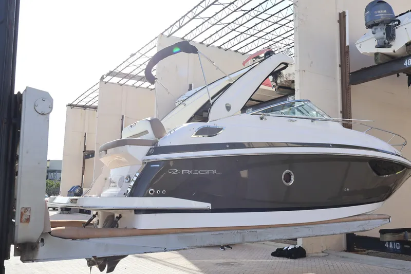 Slide: The Image of 2018 Regal 28 Express boat lifted in a marina storage facility. - 3
