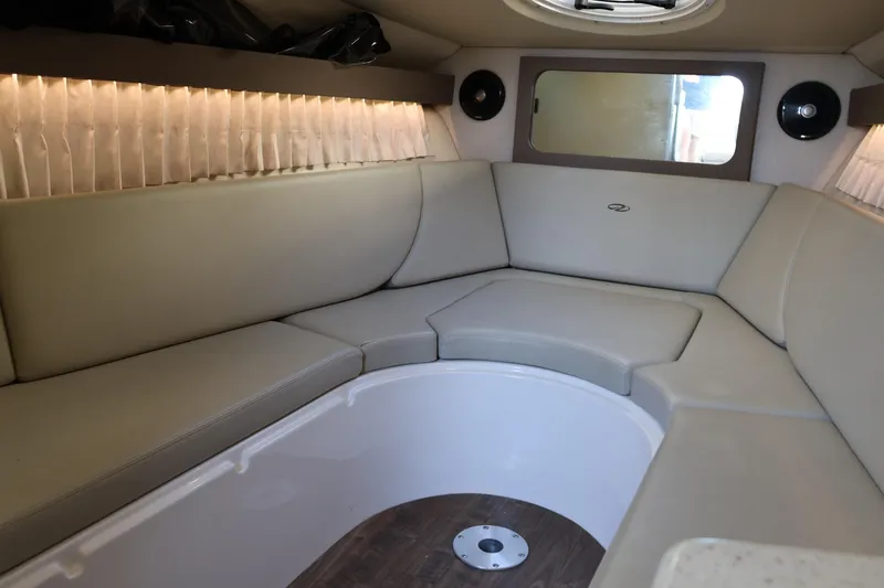 Slide: The Image of Interior of 2018 Regal 28 Express boat with beige seating and wood flooring. - 30