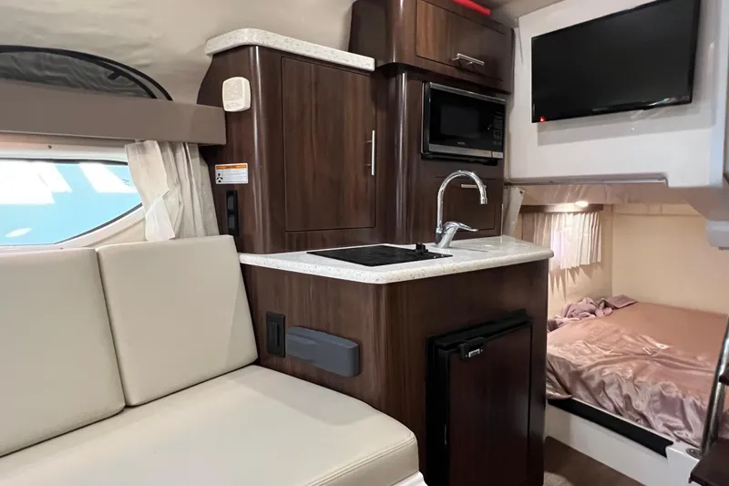 Slide: The Image of 2018 Regal 28 Express interior with kitchenette, seating, and sleeping area. - 31