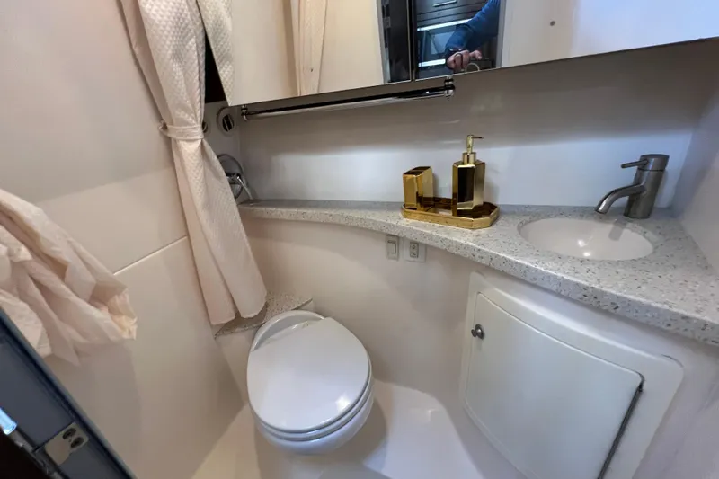 Slide: The Image of 2018 Regal 28 Express boat bathroom with sink, toilet, and gold accessories. - 38