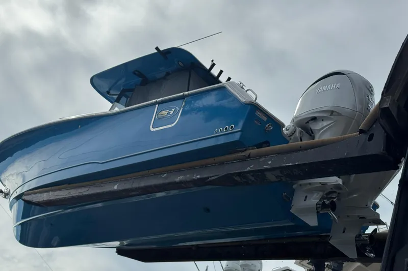 Slide: The Image of 2024 Sea Hunt Ultra 305 SE boat with Yamaha engine, viewed from below against cloudy sky. - 18