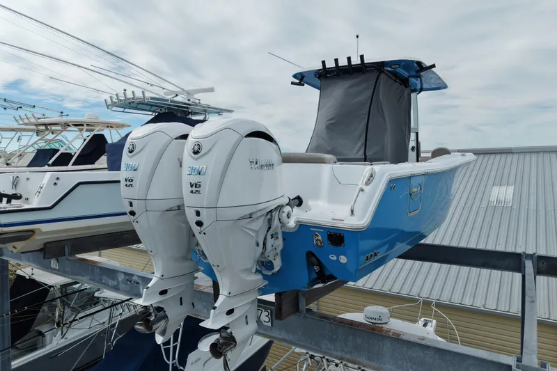 Slide: The Image of 2024 Sea Hunt Ultra 305 SE boat with twin Yamaha V6 engines on a lift. - 25