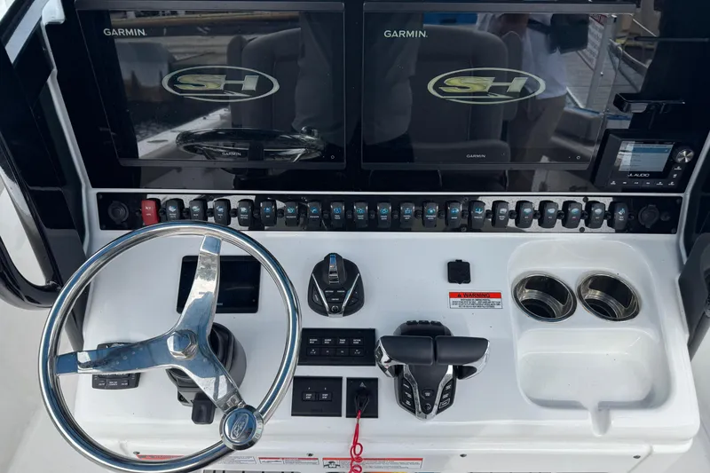 Slide: The Image of 2024 Sea Hunt Ultra 305 SE dashboard with dual Garmin displays and controls. - 6