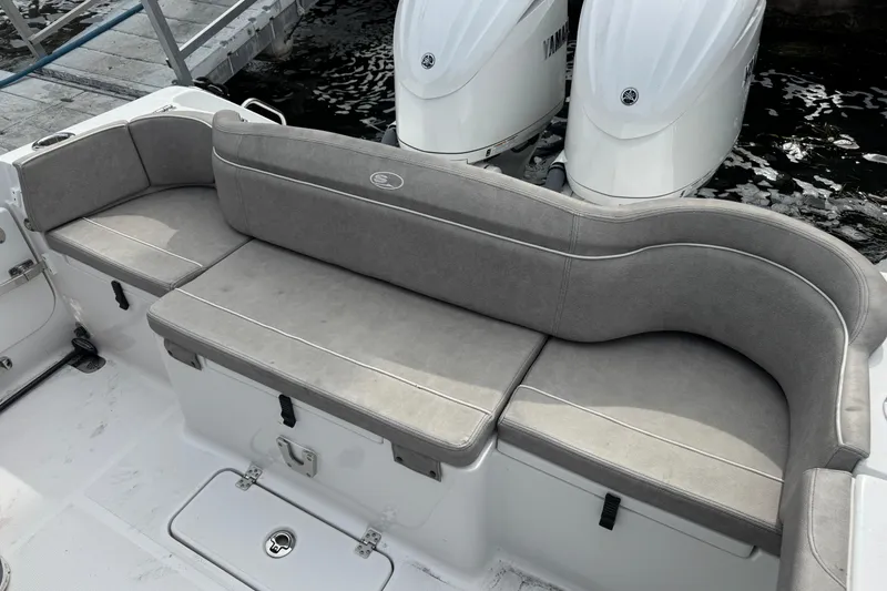 Slide: The Image of 2024 Sea Hunt Ultra 305 SE boat with gray cushioned seating and dual Yamaha engines. - 7