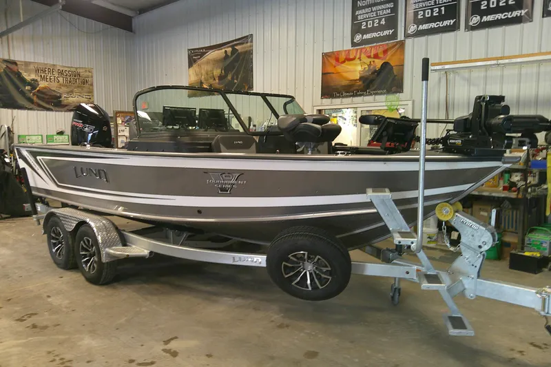 Slide: The Image of 2025 Lund 1975 Pro-V fishing boat on trailer in showroom setting. - 1