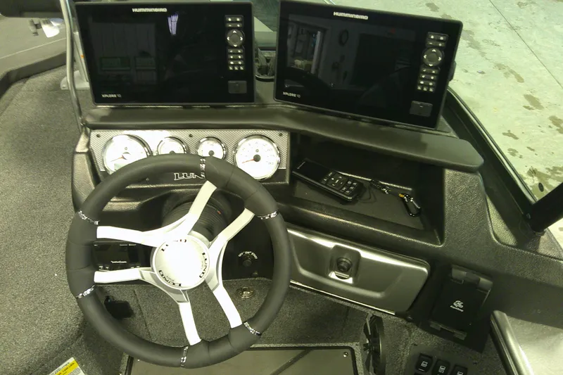 Slide: The Image of Interior of 2025 Lund 1975 Pro-V boat with advanced navigation displays and steering wheel. - 12