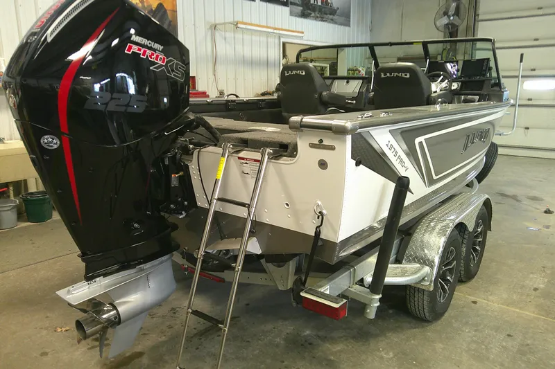 Slide: The Image of 2025 Lund 1975 Pro-V boat with Mercury Pro XS engine in a garage setting. - 3