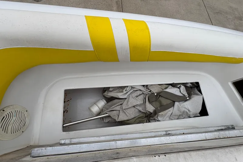 Slide: The Image of 2003 Splendor 240 Platinum boat storage compartment with yellow seat detail. - 12