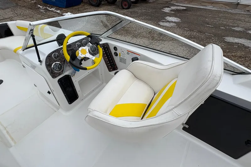 Slide: The Image of 2003 Splendor 240 Platinum boat interior with yellow accents and steering wheel. - 17