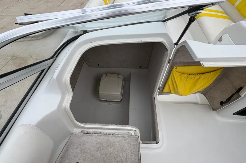 Slide: The Image of 2003 Splendor 240 Platinum boat interior with storage compartment and yellow accents. - 20