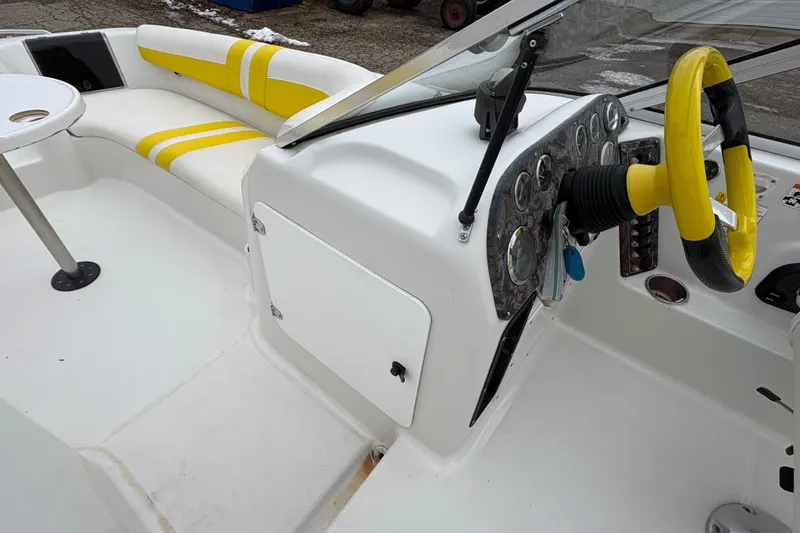 Slide: The Image of 2003 Splendor 240 Platinum boat interior with yellow accents and steering wheel. - 21